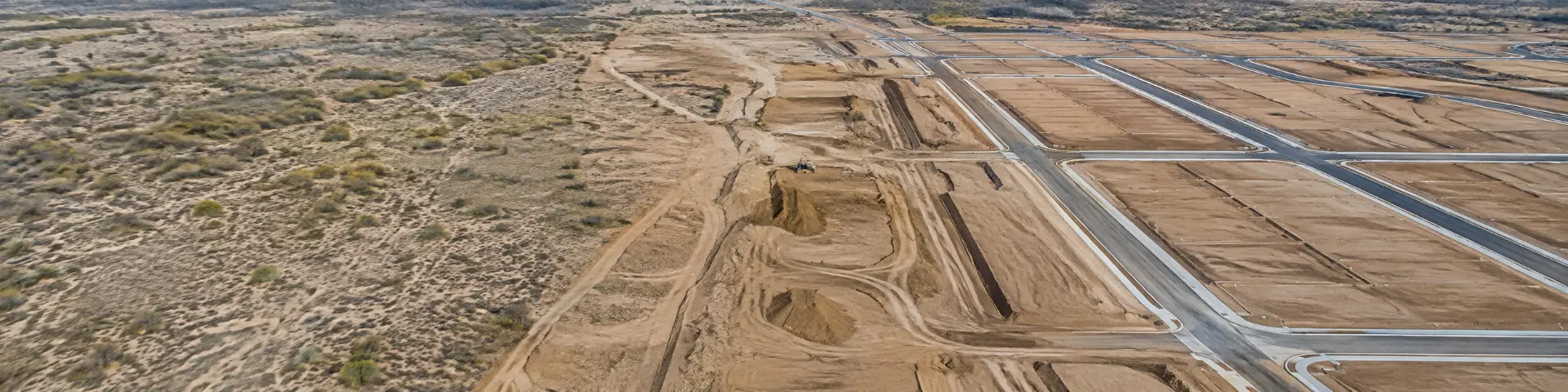 Vista aérea que compara terreno en bruto con lotes ya urbanizados